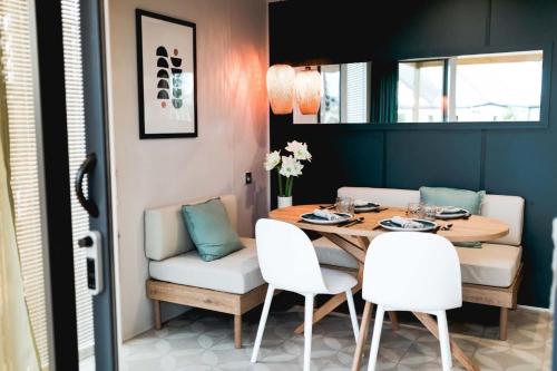 格里莫Mobil Homes Vacances的一间带桌子和白色椅子的用餐室