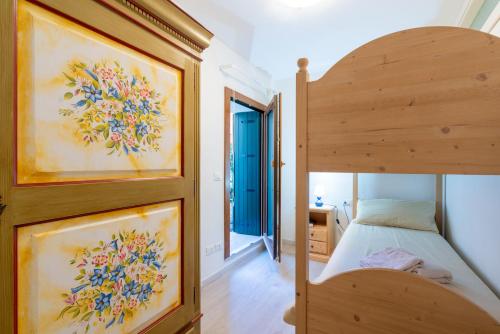 阿夏戈Asiago Centro - Comodissimo Appartamento al Piano Terra的一间卧室设有一张木制双层床和一个门廊。