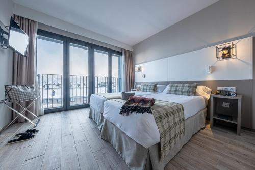 帕斯底拉卡萨Apartamentos Caribou的酒店客房设有一张床和一个大窗户