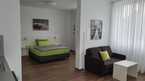 NeckarwestheimNeckarzeit的一间卧室配有一张床、一张沙发和一把椅子