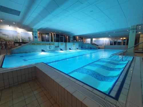 圣恩吉玛Ferienwohnung Winklworld 2 mit Hallenbad und Sauna inklusive aktivCARD的一座拥有蓝色灯光的大型游泳池