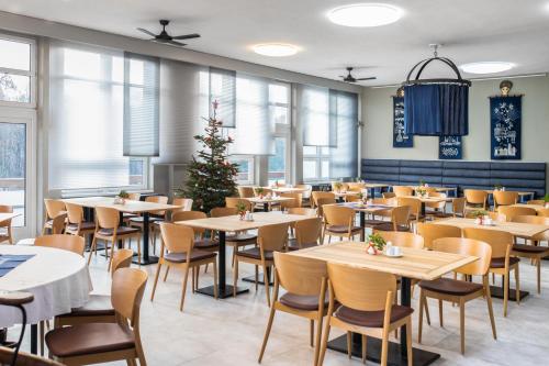 罗斯诺夫·波德·拉德霍斯滕ibis Styles Relax Roznov pod Radhostem的一间餐厅,配有桌椅和圣诞树