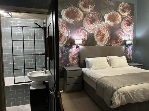 尚克林昆西米德酒店的一间卧室配有一张床,浴室墙上挂着玫瑰花。