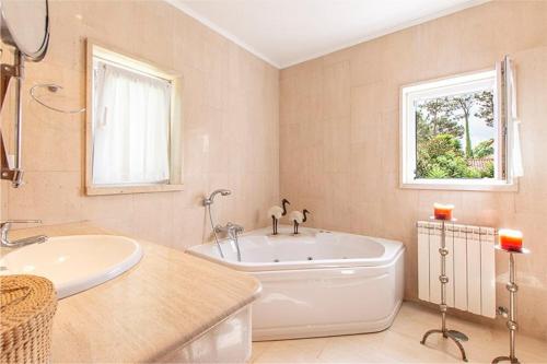 AroeiraVilla Alecrim的白色的浴室设有浴缸和水槽。
