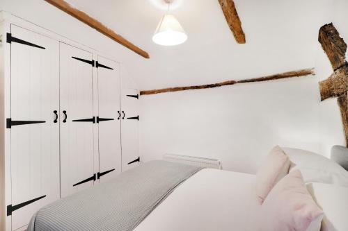 罗伯茨布里奇Perfectly Presented Cottage Pass the Keys的白色卧室配有一张床和白色橱柜