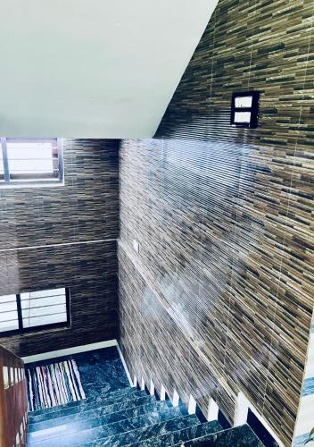戈德亚姆Puthookkadans Mareena Lodge的一间设有大砖墙和淋浴的浴室