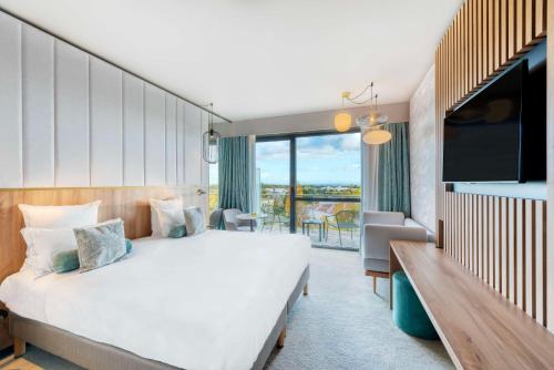 利莫内GOLDEN TULIP LYON OUEST TECHLID Hotel & Spa的酒店客房设有一张大床和一台电视机。