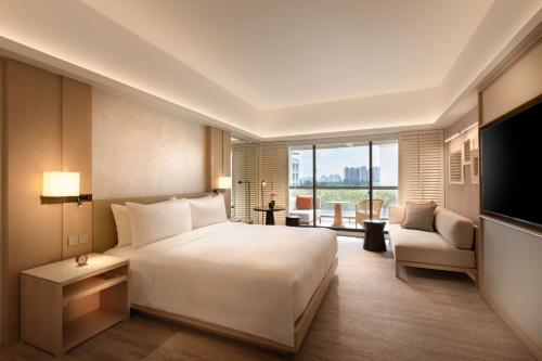 新加坡Conrad Singapore Orchard的卧室配有一张白色大床和电视。