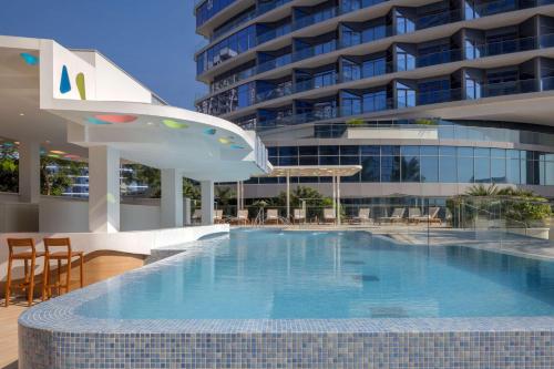 迪拜Hilton Dubai Creek Hotel & Residences的大楼前的大型游泳池
