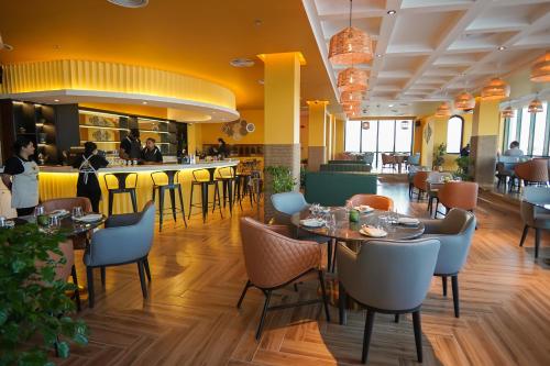 迪拜Concorde Creek View Hotel Bur Dubai的一间带桌椅的餐厅和一间酒吧
