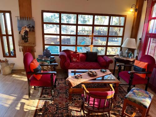 胡塞马Les IRIS的客厅配有红色的沙发和椅子