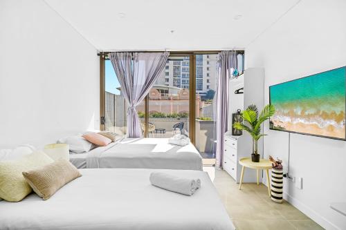 悉尼Arthur's Hotel Bondi Junction的带大窗户的客房内的两张床
