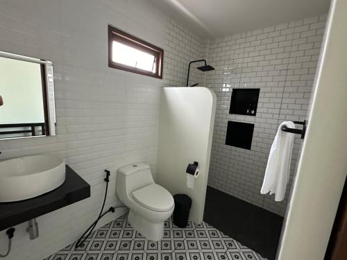 Tha SalaChansi Beachresort的白色的浴室设有卫生间和水槽。