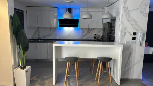 纳布勒Appartement La Croisette的白色的厨房配有白色的柜台和凳子