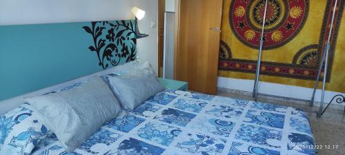 莫切Apartamento Luminoso el Morche的一间卧室配有一张带蓝色和白色被子的床