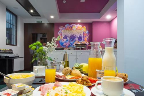格拉纳达Casual Ilbira Granada的早餐桌,包括早餐食品和橙汁