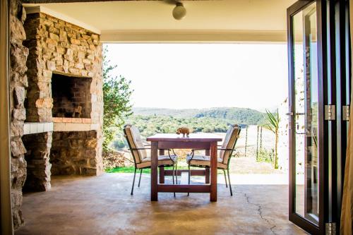 格拉罕镇African Safari Lodge的一间带桌子和石头壁炉的用餐室