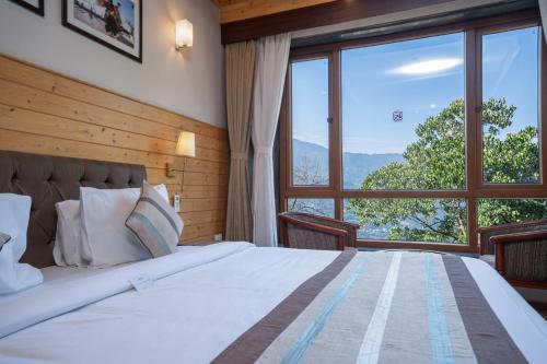 甘托克Summit Alpine Abode Hotel Centrally Air Conditioned的一间卧室设有一张大床和大窗户