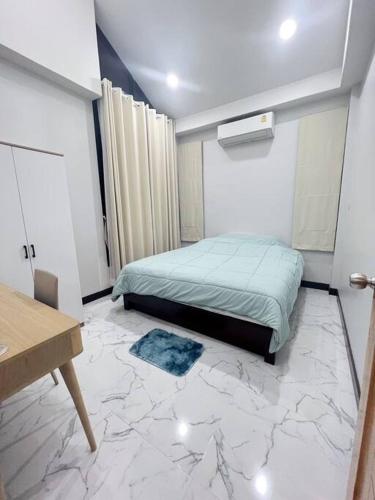 帕府Chaya Home&Hug Phrae的一间铺有大理石地板的卧室,配有一张床。