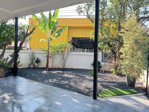 帕府Chaya Home&Hug Phrae的后院设有黄色房屋和围栏