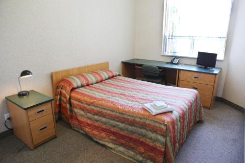 巴里公寓及会议中心酒店 - 巴里的一间卧室配有一张床、一张桌子和一张四柱床。