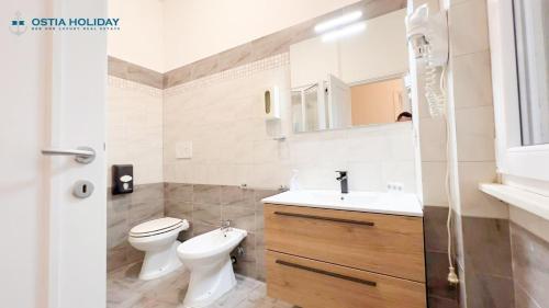 丽都迪奥斯蒂亚特拉蒙塔纳公寓的白色的浴室设有卫生间和水槽。