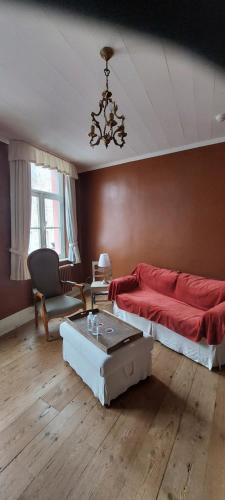 布鲁日Heerlijke Studio in centrum van Brugge的一间卧室配有红色的床和一张桌子