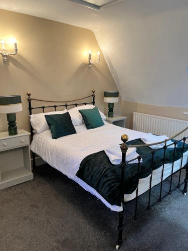 EmpinghamWhite horse的一间卧室配有一张带白色床单和绿色枕头的大床。