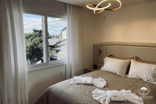 卡内拉Apartamento Novo Aconchegante e Moderno em Canela的一间卧室配有带毛巾的床