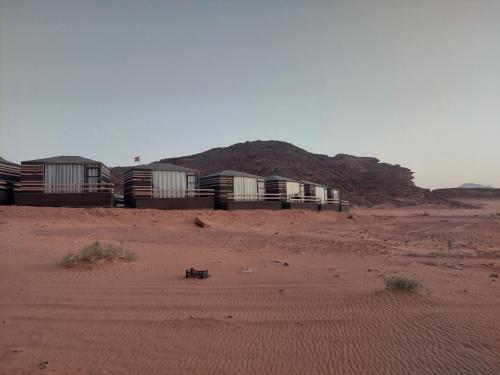 瓦迪拉姆Hakuna matata desert camp的沙漠中的一排建筑物,有山
