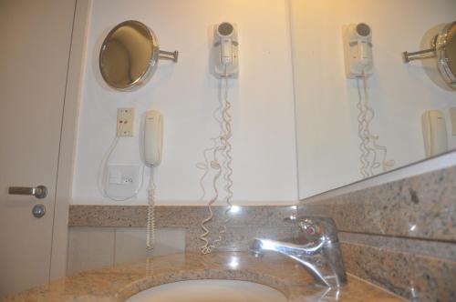 安格拉杜斯雷斯Flat em Resort Paradisíaco!的浴室设有2部电话和1个水槽