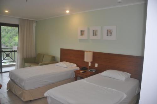 安格拉杜斯雷斯Flat em Resort Paradisíaco!的酒店客房,配有两张床和椅子