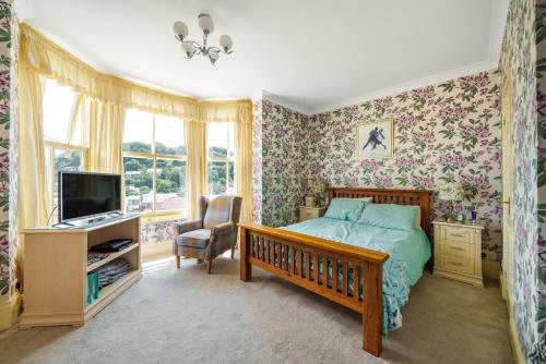 林顿Ingleside的一间卧室配有一张床、一张书桌和一台电视。