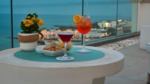 萨维勒特里Bianco Riccio Suite Hotel的一张桌子上的两杯饮料,享有海景