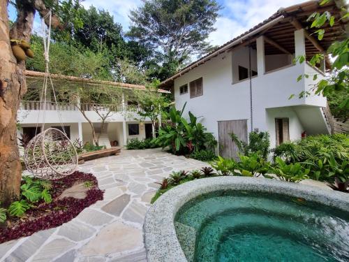 托兰克索Hotel Boutique Vila São João的一个带游泳池和房子的后院