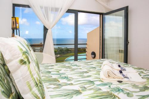 劳林哈Casa Menezes的一间卧室设有一张床,享有海景