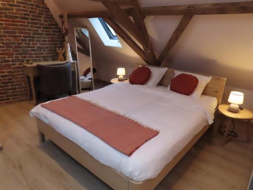 贝尔内姆B&B Den Bruynen Bergh的卧室配有带红色枕头的大型白色床