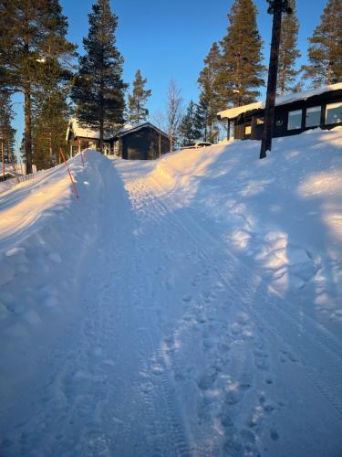 洛夫斯达伦1125 Fjällstugan的一片雪地,后面有一座房子