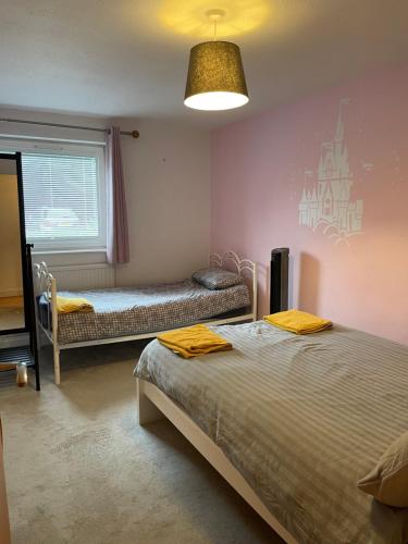 阿克斯桥Spacious Apartment near Heathrow with Allocated Parking的一间卧室设有两张床和窗户。