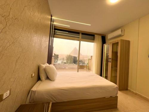开罗Giza Pyramids View Inn的一间卧室设有一张大床和窗户