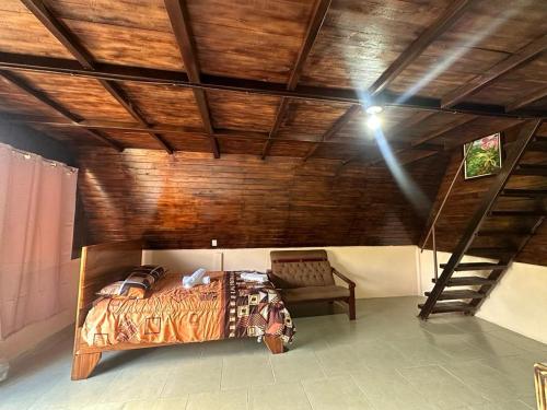 San RafaelBungalows Tenorio Montand Lodge的一间卧室设有一张床和木制天花板