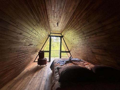 San RafaelBungalows Tenorio Montand Lodge的卧室设有木墙内的大窗户