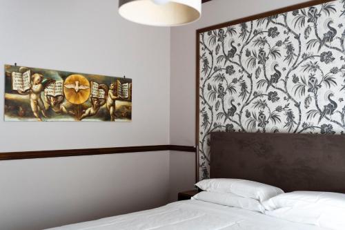 福贾Affittacamere Le Dimore del Riccio的卧室,墙上挂着一幅画,床边是