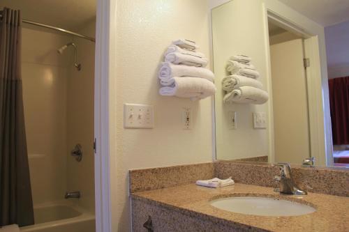 恩菲尔德哈特福德恩菲尔德6号汽车旅馆的浴室配有盥洗盆、镜子和毛巾