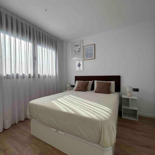 略夫雷加特河畔圣费柳Estrénalo a minutos de BCN的白色的卧室设有一张大床和一个窗户