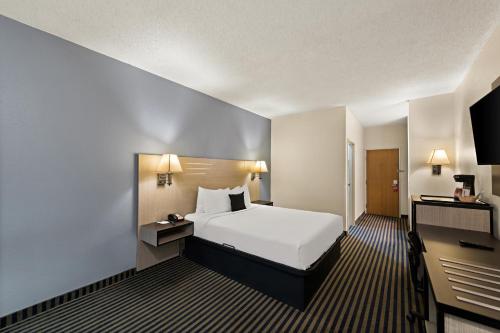 GretnaRed Lion Inn & Suites Gretna的配有一张床和一张书桌的酒店客房