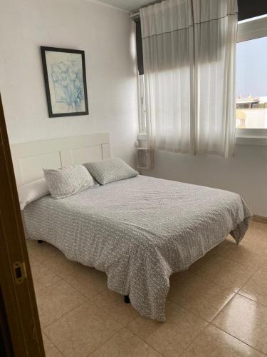 维辛达里奥Room Sol Vecindario Gran Canaria的一间带床的卧室,位于带窗户的房间内