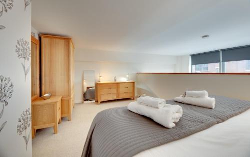 泰恩河畔纽卡斯尔Crown Apartments 104 by Week2Week的一间卧室配有带毛巾的床