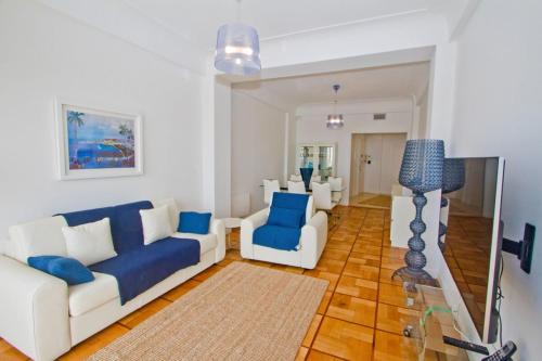 尼斯Promenade des Anglais - Sea View 2bdr的客厅配有白色沙发和蓝色椅子
