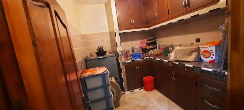 达赫拉Dar Salam的厨房配有木制橱柜和黑色冰箱。